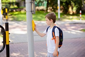Boy pressing crosswalk sign